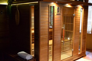 A sauna room with wooden walls, a bench, and a towel. - Massages du Monde (Saint-Georges-sur-la-Prée)