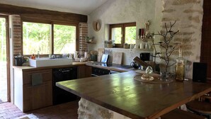 Una cucina rustica con una grande isola, mobili in legno e un muro in mattoni.