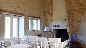 Une pièce rustique avec une cheminée, un lit et un coin repas.