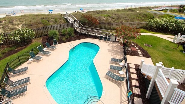 A swimming pool with a view of the beach and ocean.