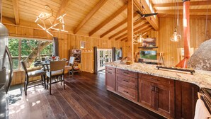 A spacious kitchen with wooden beams, granite countertops, and a large island. - Unique Modern Cabin w/spa, dry sauna (Idyllwild)