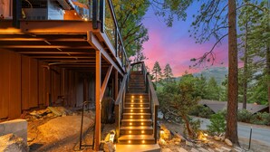 A staircase leading to a wooden deck with a metal railing, surrounded by trees and a clear sky. - Unique Modern Cabin w/spa, dry sauna (Idyllwild)