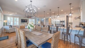 A spacious kitchen with a central island, modern appliances, and pendant lighting. - 6-Bedroom Luxury House with Pool, Steps to Beach (Isle of Palms)