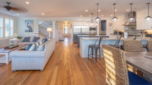 A spacious kitchen with a central island, modern appliances, and pendant lighting. - 6-Bedroom Luxury House with Pool, Steps to Beach (Isle of Palms)