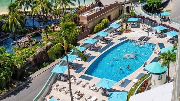 A resort pool area with multiple pools, sun loungers, and umbrellas. - @ Marbella Lane - Executive Suite | Steps to Beach (Honolulu)