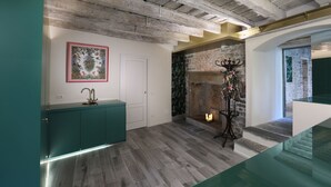 Um interior moderno com vigas de madeira aparentes, lareira e um armário cor de verde-água.