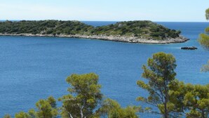 Une vue sur la côte, avec une petite île entourée d’une eau d’un bleu limpide.