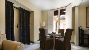 A room with a beige sofa, two brown armchairs, a small round table with fruit, a floor lamp, and a window with a view of a balcony. - UR-NEST d'Azeglio, Elegant one bedroom apartment (Bologna)