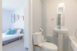A modern bathroom with a toilet, sink, and mirror.