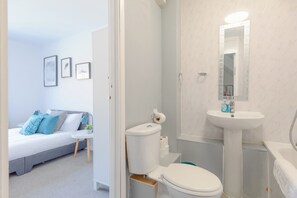A modern bathroom with a toilet, sink, and mirror.