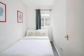 A bedroom with a bed, a window with a curtain, and a door. - Modern 2BDR City Retreat Angel & Shoreditch Border (London)