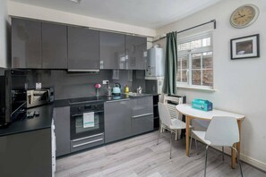 Mikrobølgeovn, ovn, kjøkkenutstyr og spisebord