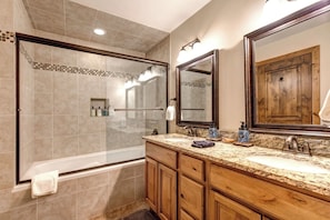 Bathtub, hair dryer, towels, shampoo