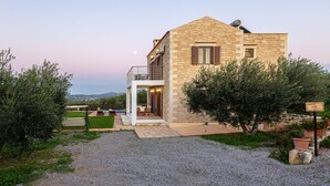 Ein Steinhaus mit Balkon, Pool und Blick auf die Landschaft.