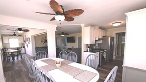 A spacious kitchen with modern appliances, a dining area with a large table and chairs, and a ceiling fan. - Shuckers & Beaches!  In Beautiful Mexico Beach, FL (Mexico Beach)
