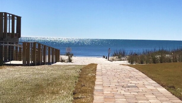 A pathway leading to a beach with a wooden structure on the left. - Shuckers & Beaches!  In Beautiful Mexico Beach, FL (Mexico Beach)