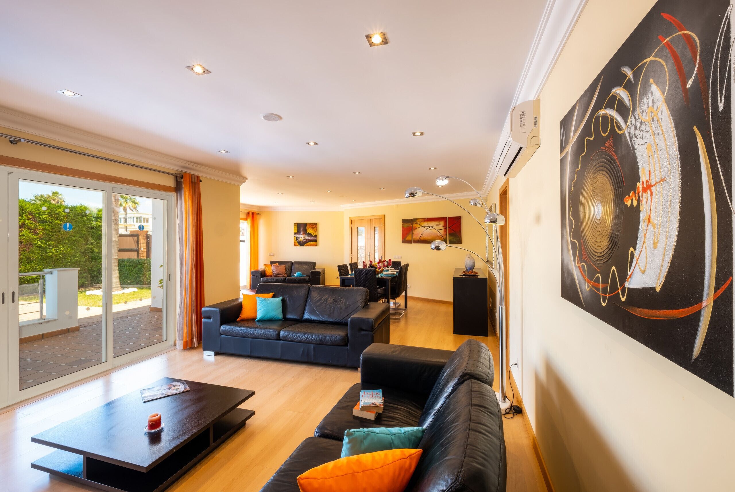 A modern living room with a sofa, coffee table, and artwork on the wall.