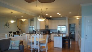 A spacious kitchen with white cabinets, a central island, and modern appliances. - Turtle Bay 15 - Riverfront - Dock & Pool (Folly Beach)