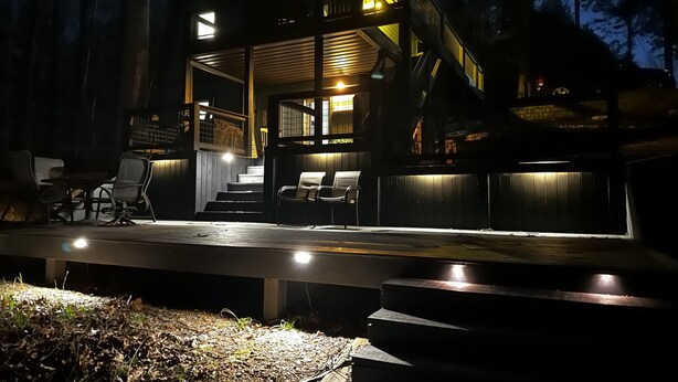 A modern outdoor deck with a staircase leading to a covered area, surrounded by trees. - Barren Lake Waterfront Eclectic Cabin - Dock; 17 miles from Mammoth Cave (Glasgow)