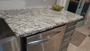 A kitchen with a marble countertop, stainless steel appliances, and a decorative bowl. - Totally Renovated  with Amazing Kitchen, Luxurious Master Suie and Private Pool  (Lake Charles)