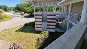 A gazebo with a tiled roof, a covered walkway, and a bicycle parked nearby. - Appartement à la mer (Soulac-sur-Mer)