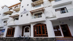 A white building with balconies and wooden window frames, labeled "Grand Hotel Leon Marino." - Grand Hotel Leon Marino Galapagos (Puerto Ayora)