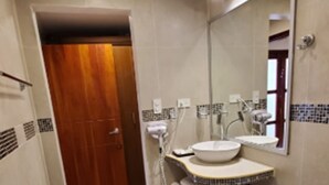 A modern bathroom with a toilet, two sinks, and a mirror. - Grand Hotel Leon Marino Galapagos (Puerto Ayora)