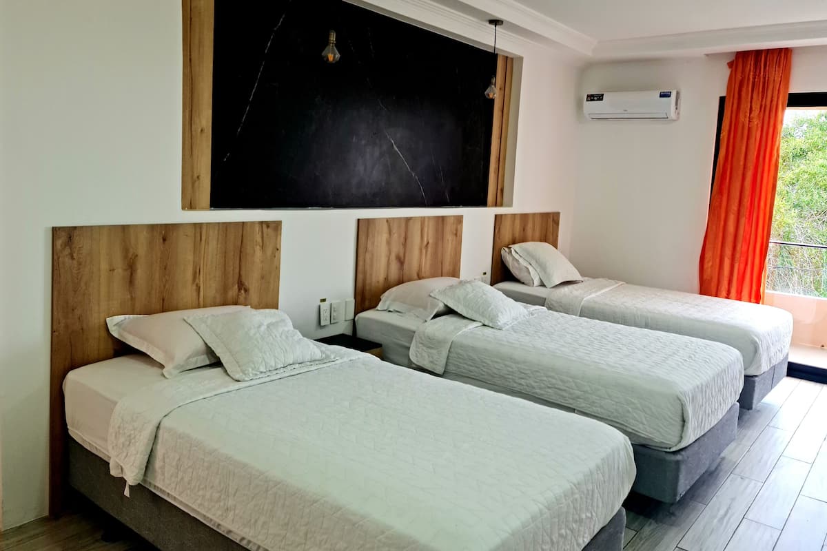 Habitación triple Confort | Escritorio y ropa de cama