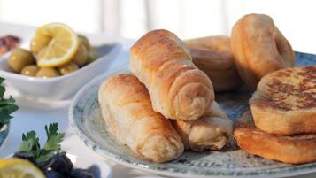 Un plato de croissants y un bol de aceitunas sobre una mesa.