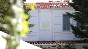 A building with a sign reading "Milia Sukuk Otel" and a tiled roof. - NİLİA BOZCAADA (Bozcaada)
