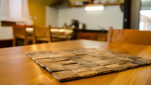 Un tavolo di legno con un sottopiattino intrecciato.