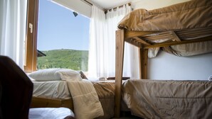 Camera con letto a castello e finestra vista su un paesaggio verde.