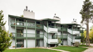 A multi-story building with balconies, a staircase, and a well-maintained lawn. - Outpost: Spruces 10 - Located in the Aspens! (Wilson)