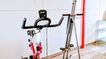Une salle de sport équipée d’un vélo d’exercice et d’un tapis de course.