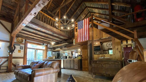 L’intérieur d’un chalet rustique comprend un espace de vie chaleureux, une cuisine et une chambre à coucher située en mezzanine.