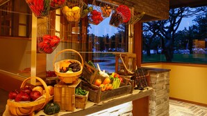 Un plan de travail de cuisine sur lequel sont disposés divers fruits et légumes présentés dans des paniers et des caisses en bois.