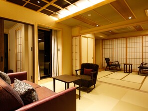 A traditional Japanese-style room with tatami flooring, a low table, and seating arrangements. - Awaji Hamarikyu TAKUMI (Minamiawaji)