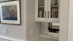A kitchen with white cabinetry, a countertop, and a framed picture on the wall.