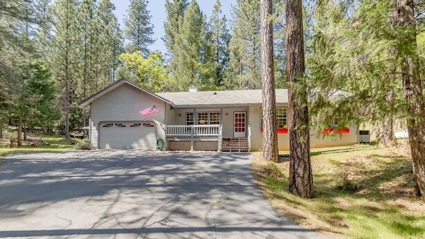A single-story house with a front porch, a garage, and a driveway leading to the entrance. - Charming home in Sierra Nevada Foothills (Foresthill)
