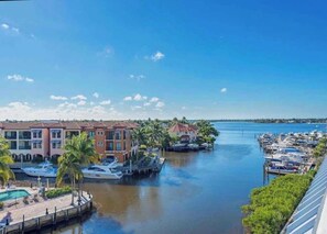 A marina with boats, a dock, and buildings with a water view.