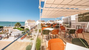 A terrace with outdoor seating, a view of the sea, and a building with a white facade. - Soul Beach Hotel By Mc Adults Recommended (Denia)