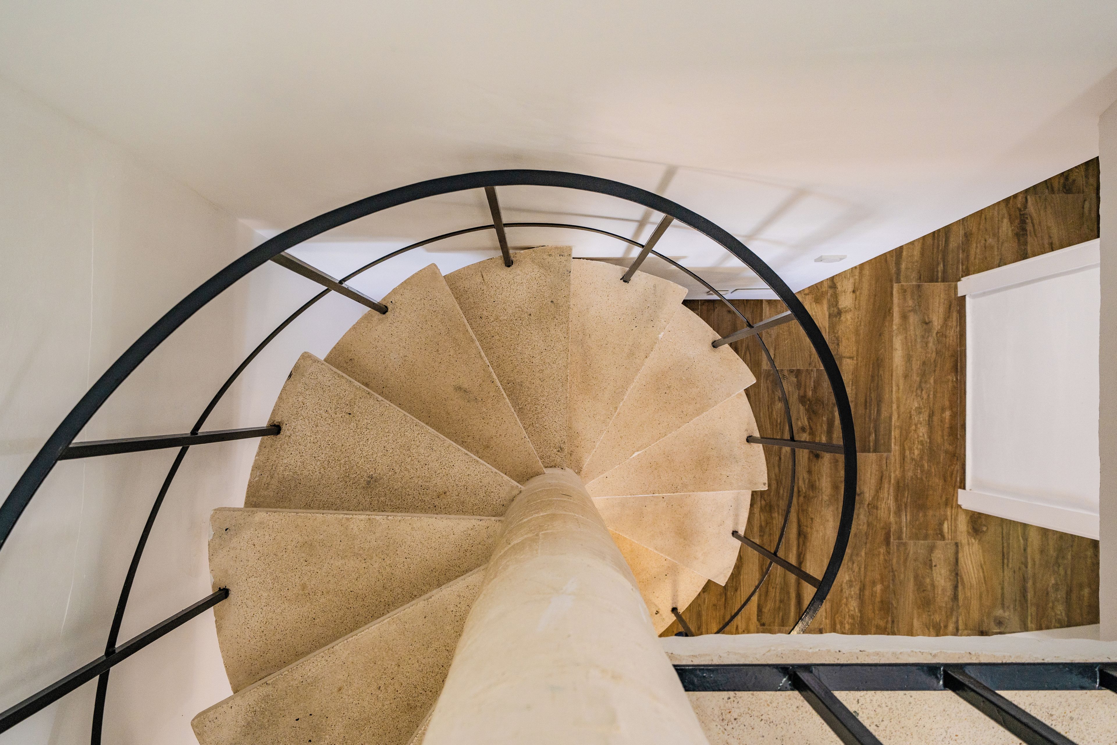 Una escalera de caracol con pared de madera y barandilla de metal.