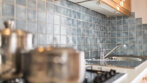 A kitchen with a tiled backsplash, a stainless steel sink, and a stove. - Holiday Apartment "3 - Ciasa Primula" (san Vigilio di Marebbe)