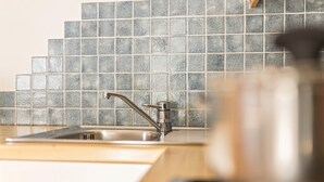 A kitchen with a sink, a tiled backsplash, and a countertop.