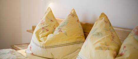 A bed with floral-patterned pillows and a matching blanket.