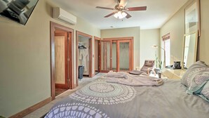 A bedroom with a bed, a ceiling fan, a wardrobe, and a mirror. - Hip Midtown Detroit Hub, Walk to Woodward Ave (Detroit)