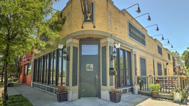 A corner building with a green door, large windows, and a sign reading "Woodbridge Pub". - Hip Midtown Detroit Hub, Walk to Woodward Ave (Detroit)