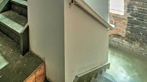 A staircase with a white handrail and a brick wall. - Hip Midtown Detroit Hub, Walk to Woodward Ave (Detroit)