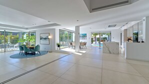 Un hall d’hôtel spacieux et moderne, doté d’un espace repas, de grandes fenêtres et offrant une vue sur l’extérieur.
