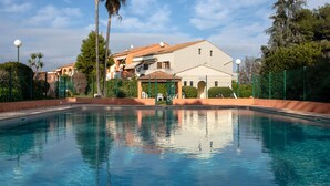A swimming pool with a clear view of a building in the background. - La Calmeraie by Interhome (Villeneuve-Loubet)